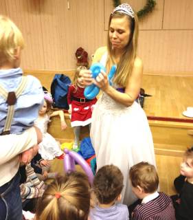 Barn flockas kring Helena Lewin som viker ballonger.