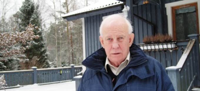 Hans Bengtsson framför villan i Norrtälje. Han har vitt hår och blå jacka.