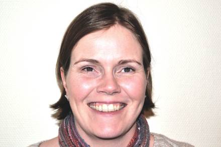 Leende kvinna med brunt hår.