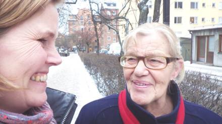 Två kvinnor tittar varmt på varandra och ler.