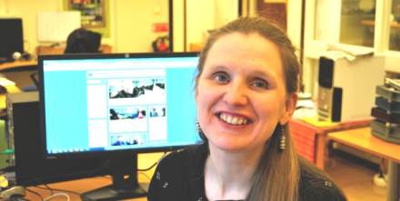Ulrika Norelius har långt mörkblont hår och sitter framför en datorskärm som visar den nya hemsidan.
